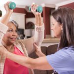 caregiver helping with physical fitness for senior client