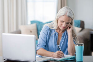 A woman utilizes time management tips for caregivers as she makes a note in her daily planner.