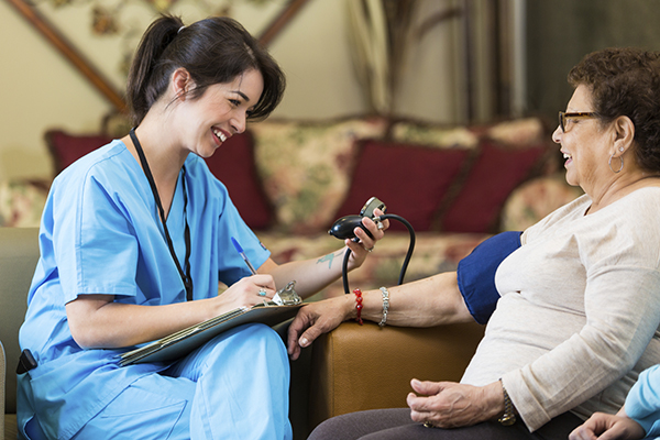 Caregiver taking client's blood pressure