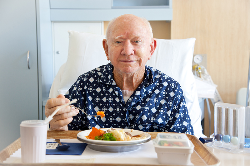 Senior man eating a meal in the hospital