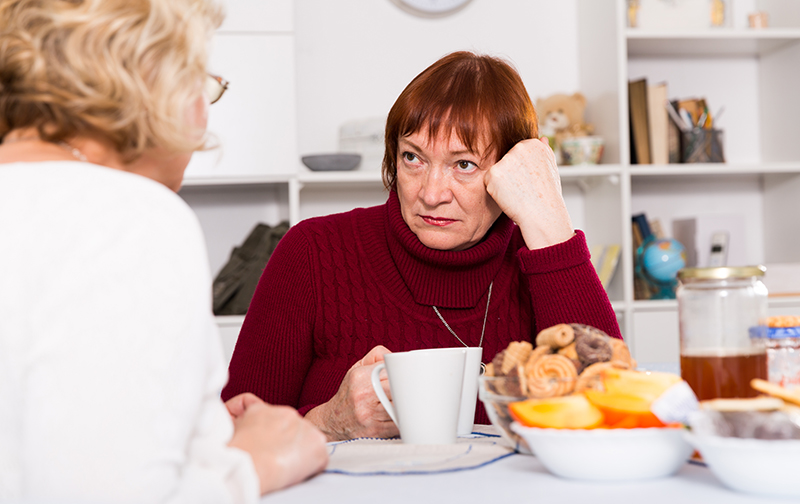 Stressed senior woman talking with female