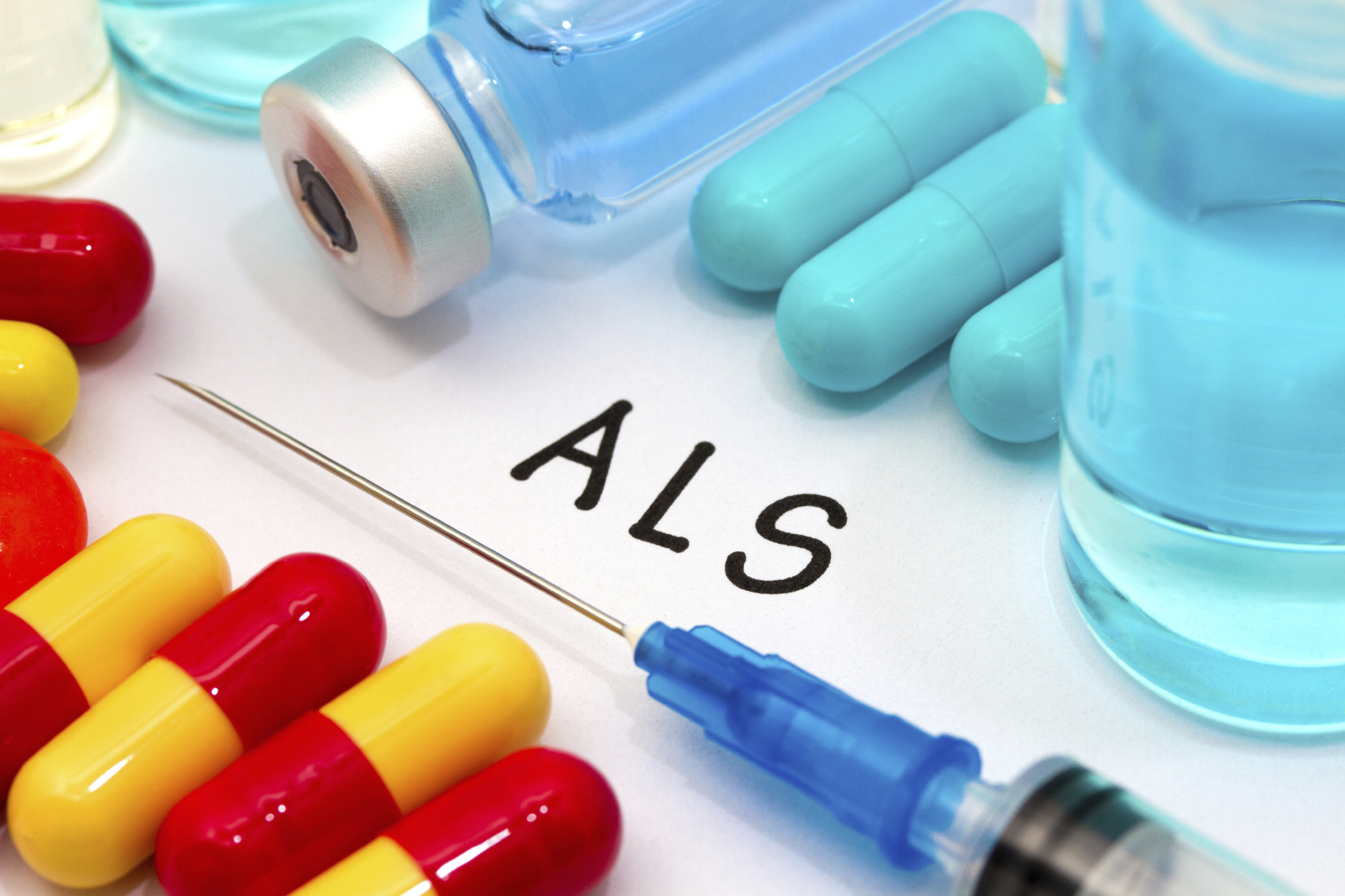 Different medications surround a syringe, indicating various treatments for each stage of ALS.