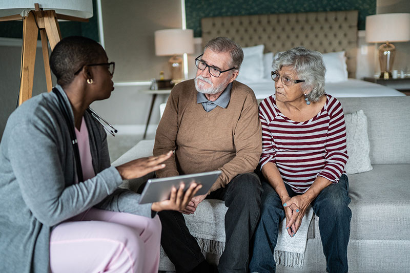 A care manager discusses skilled home health care services with a senior couple.